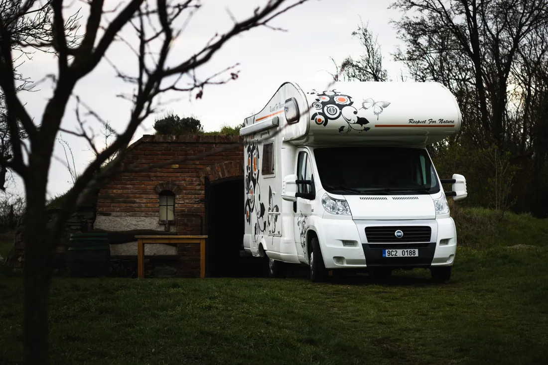 Camping-car : bien choisir son assurance avant le départ 3 Courtier Assurances et Financements Rennes Camping-car blanc stationné à la campagne, illustrant le stationnement longue durée