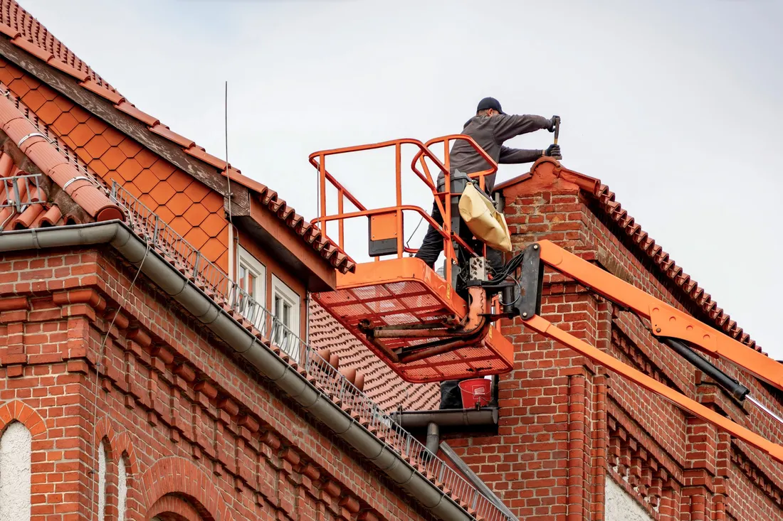 Assurance RC Pro couvreur : prix, garanties et obligation 2026 1 Courtier Assurances et Financements Rennes Couvreur en nacelle sur une toiture, garanties RC Pro