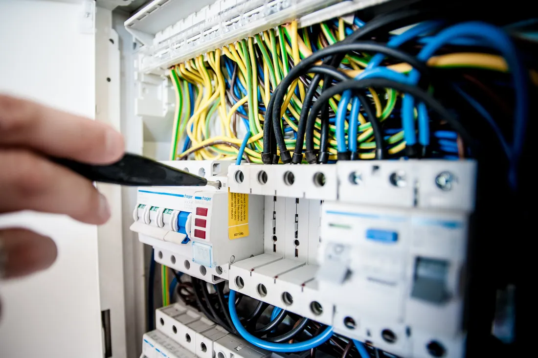 Assurance RC Pro électricien : prix, garanties et obligation 2026 2 Courtier Assurances et Financements Rennes Mains d'électricien sur le câblage d'un tableau, assurance responsabilité civile professionnelle