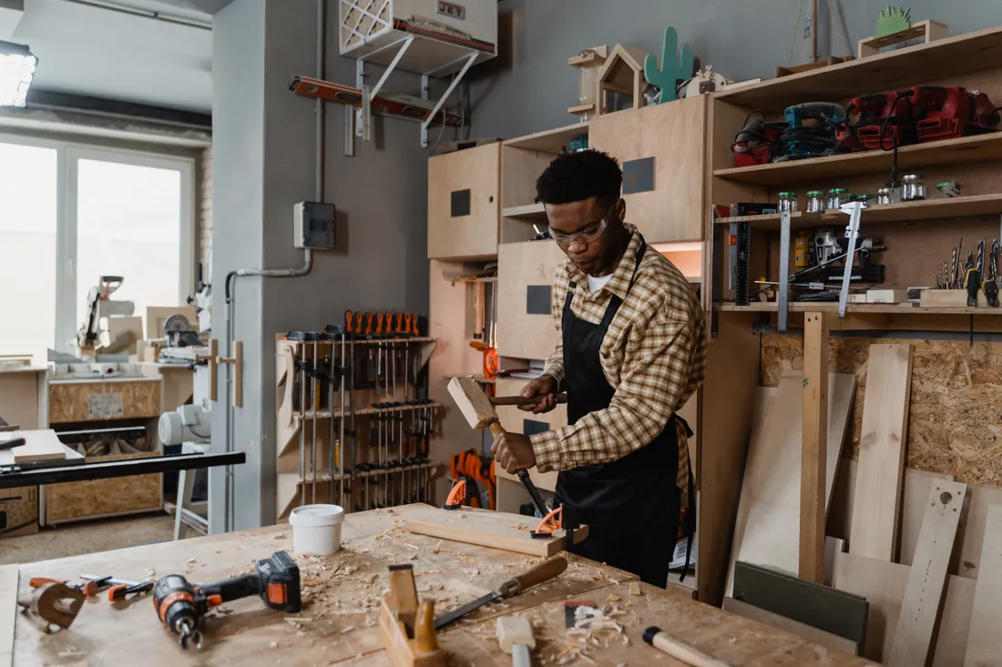 Assurance RC Pro menuisier : prix, garanties et obligation 2026 1 Courtier Assurances et Financements Rennes Menuisier sculptant une pièce de bois en atelier, garanties RC Pro