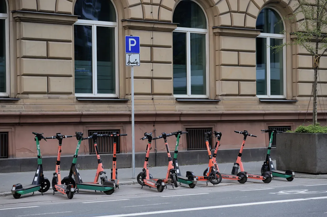 Trottinette électrique : quelle assurance pour rouler serein ? 2 Courtier Assurances et Financements Rennes Rangée de trottinettes électriques stationnées dans une rue de centre-ville européen, exposées au vol et à la casse