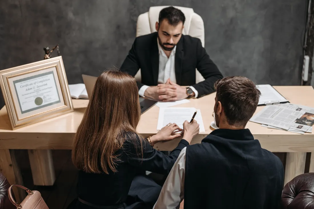 Protection juridique entreprise : anticiper les litiges du quotidien 1 Courtier Assurances et Financements Rennes Avocat expliquant des documents juridiques à des clients professionnels lors d'un accompagnement en cas de litige