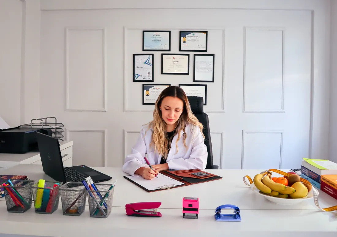 Diététicien, nutritionniste : la RC Pro qui protège vos conseils 2 Courtier Assurances et Financements Rennes Nutritionniste au bureau rédigeant un compte rendu de consultation diététique