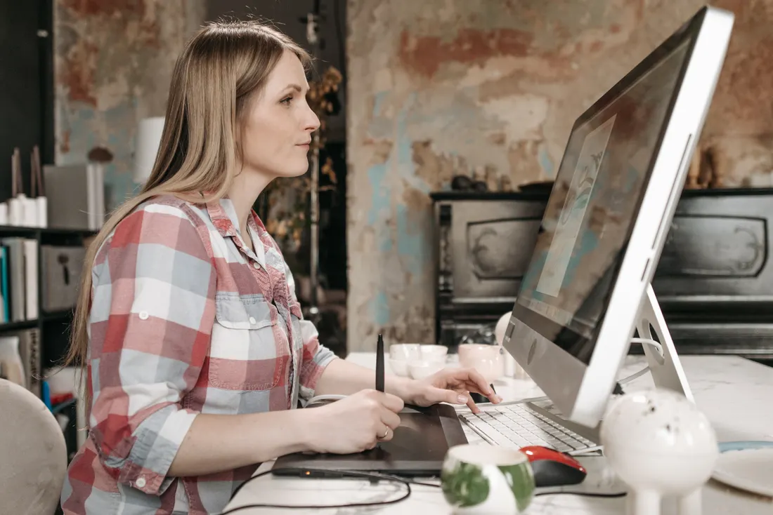 Graphiste et webdesigner : pourquoi souscrire une RC Pro 2 Courtier Assurances et Financements Rennes Webdesigner ajustant une maquette sur tablette graphique, enjeux de droits d'auteur et RC Pro