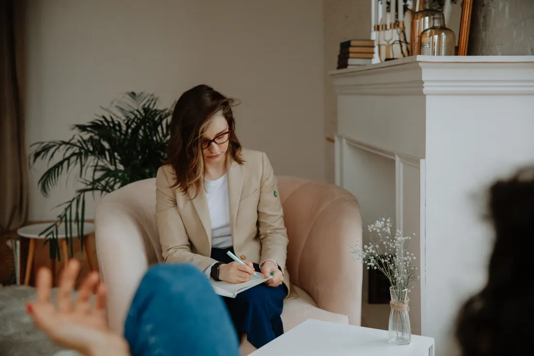Faut-il une RC Pro quand on est sophrologue ? 2 Courtier Assurances et Financements Rennes Praticienne bien-etre prenant des notes pendant une consultation individuelle en cabinet