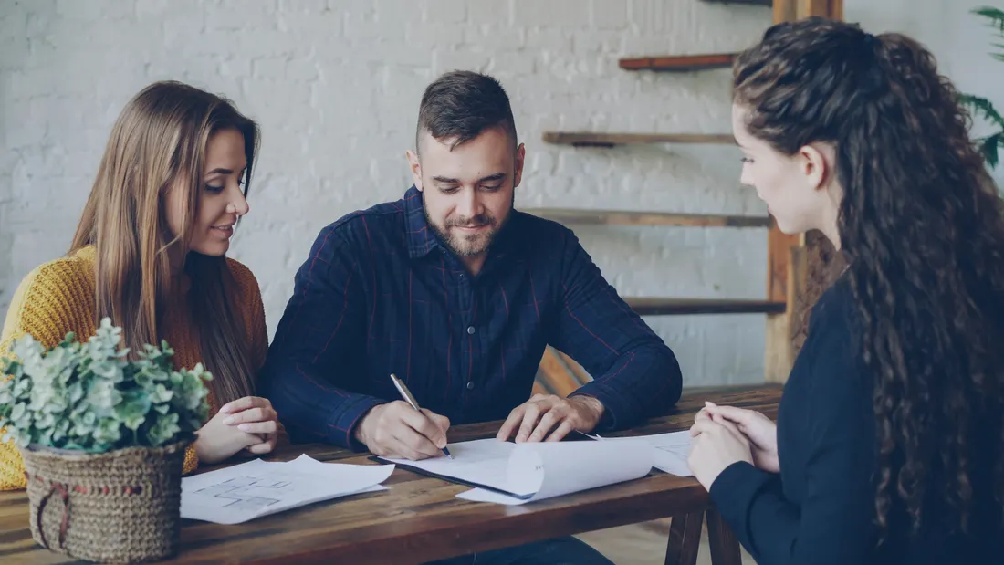Taux immobilier 2026 : où vont les taux et que faire ? 2 Courtier Assurances et Financements Rennes Jeune couple étudiant un dossier de crédit immobilier avec un courtier à Rennes