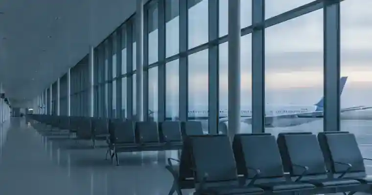 Assurance garde du corps : ce que la RC Pro doit couvrir 2 Courtier Assurances et Financements Rennes Couloir d'embarquement désert dans un aéroport, sièges vides et grandes baies vitrées