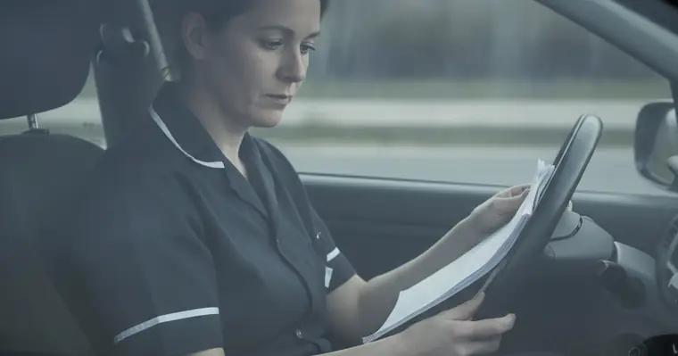 Prévoyance infirmière libérale : ce que verse vraiment la CARPIMKO 1 Courtier Assurances et Financements Rennes Infirmière libérale consultant ses documents au volant, entre deux visites